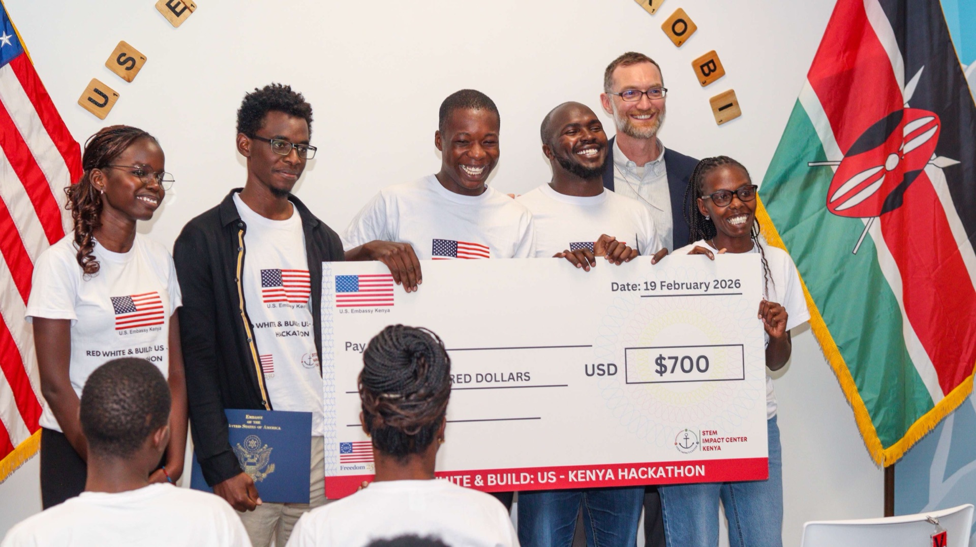 Red White and Build US-Kenya Hackathon winners receiving prize check